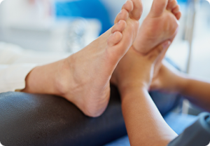 Terapeuta masuje stopę pacjenta podczas terapii w klinice.