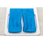 Dwie niebieskie poduszki na wagę z oznaczeniem capron na białej platformie.