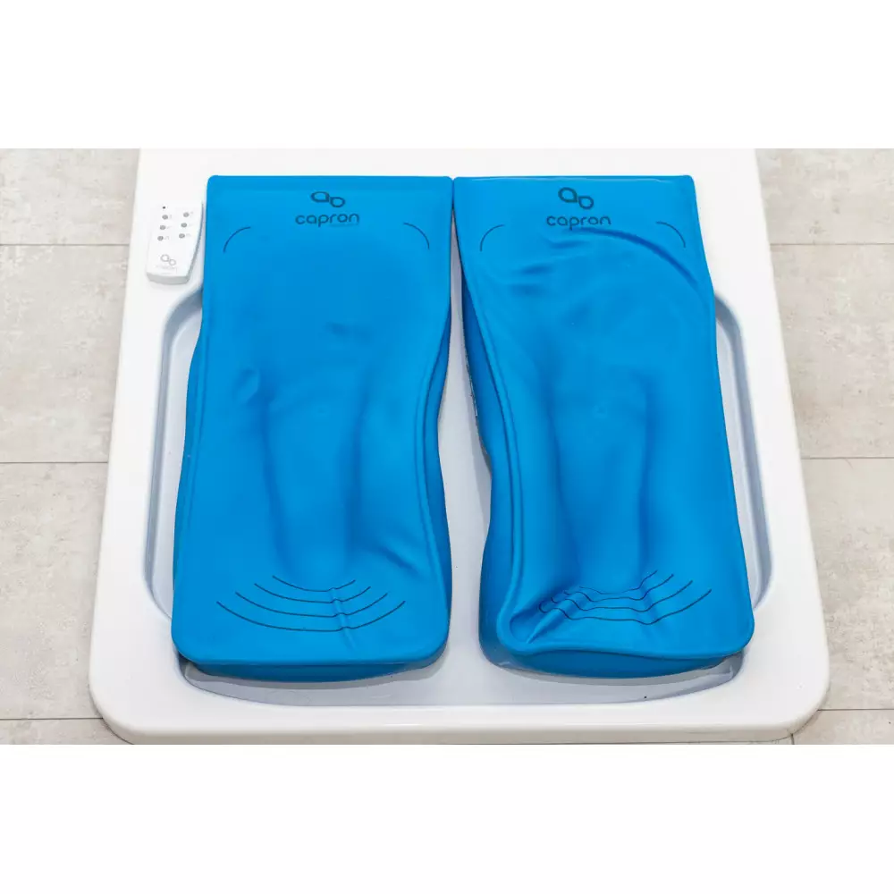 Dwie niebieskie poduszki na wagę z oznaczeniem capron na białej platformie.