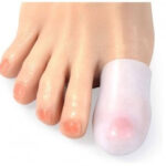 Palec u nogi z odciskiem, owinięty bandażem, na jasnym tle.