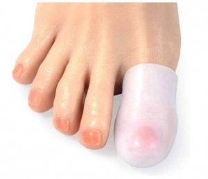 Palec u nogi z odciskiem, owinięty bandażem, na jasnym tle.