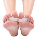 Stopy z naklejonymi na palce opaskami do pomiaru ciśnienia lub temperatury.