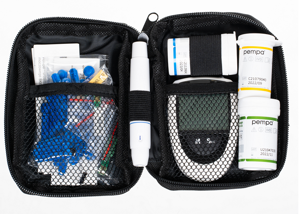 Przenośny zestaw medyczny z glukometrem, strzykawkami, insuliną i akcesoriami do pomiaru poziomu cukru we krwi.