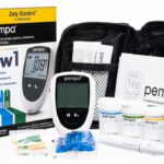 Przenośny glukometr, test paski, instrukcje, etui i próbki do pomiaru cukru we krwi.
