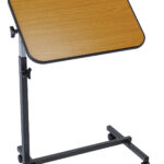 Stolik na kółkach z drewnianym blatem i regulowaną wysokością, używany do nauki lub pracy.