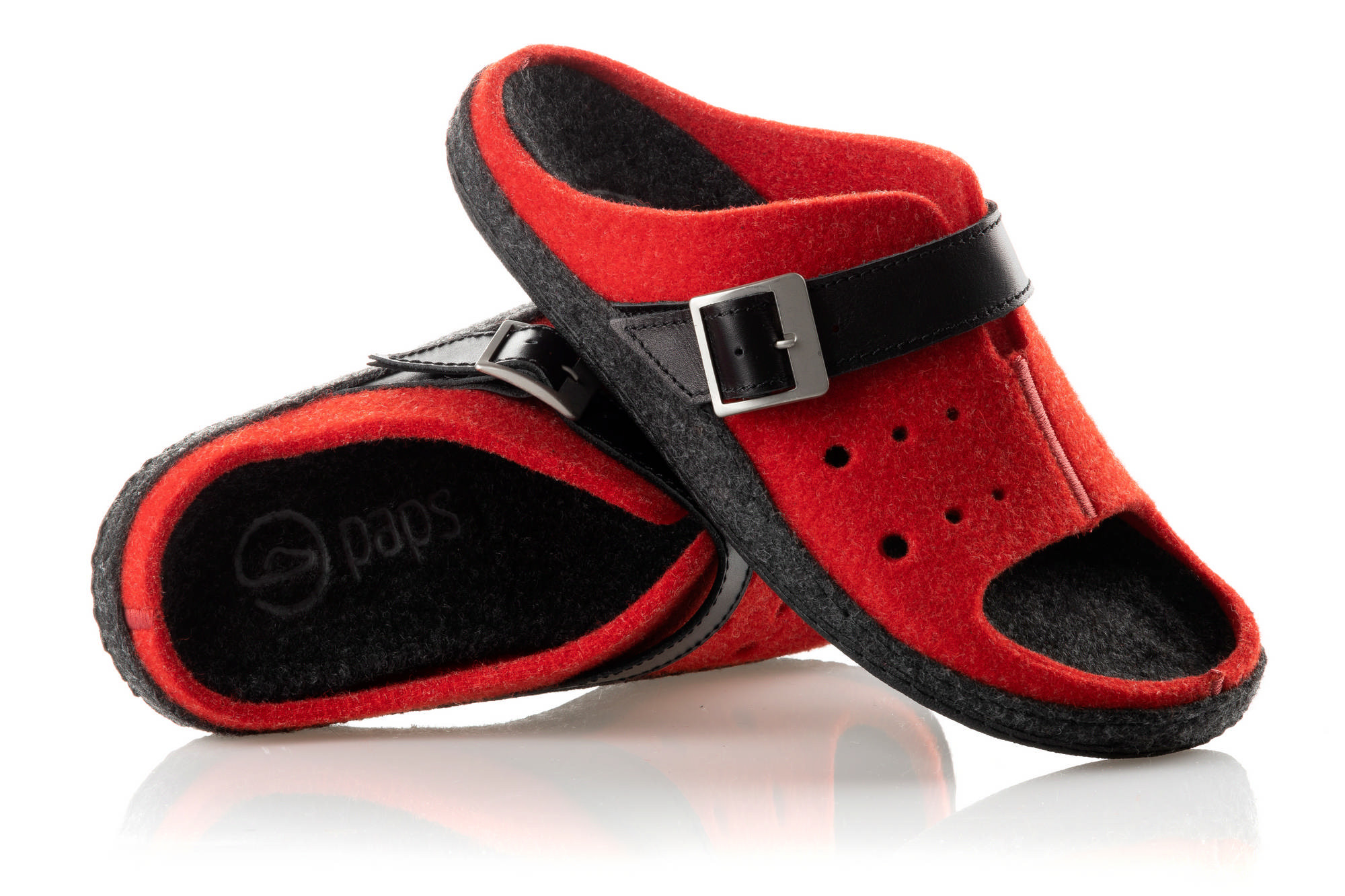Czerwone i czarne kapcie z regulowanym paskiem, wykonane z filcu, na białym tle.
