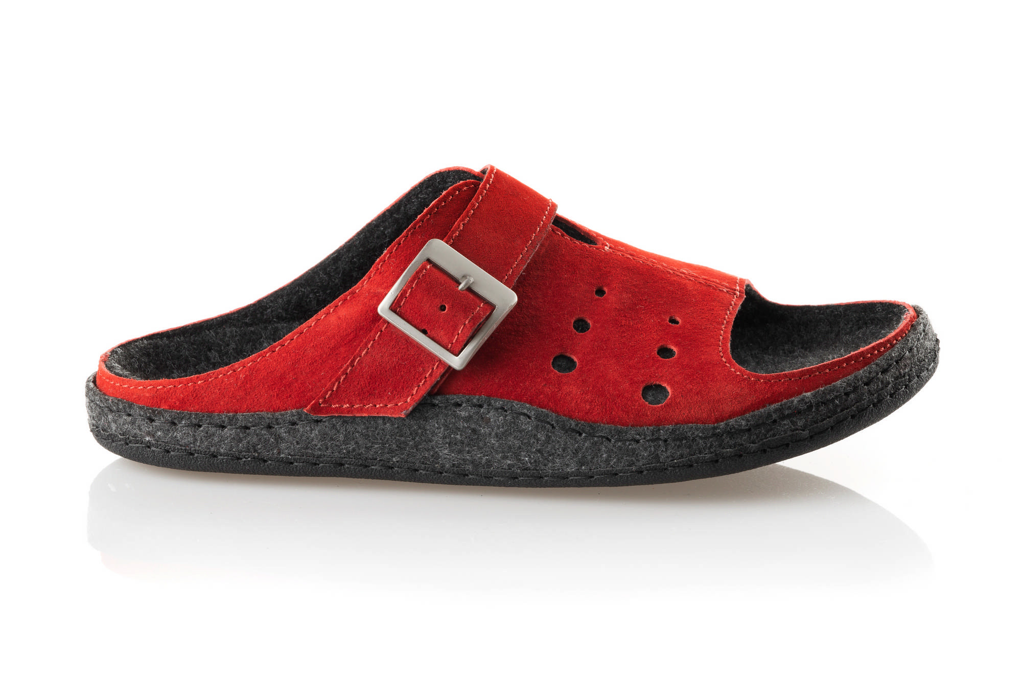 Czerwone kapcie z czarną wyściółką, pasek z metalową klamrą i perforacjami na bokach.