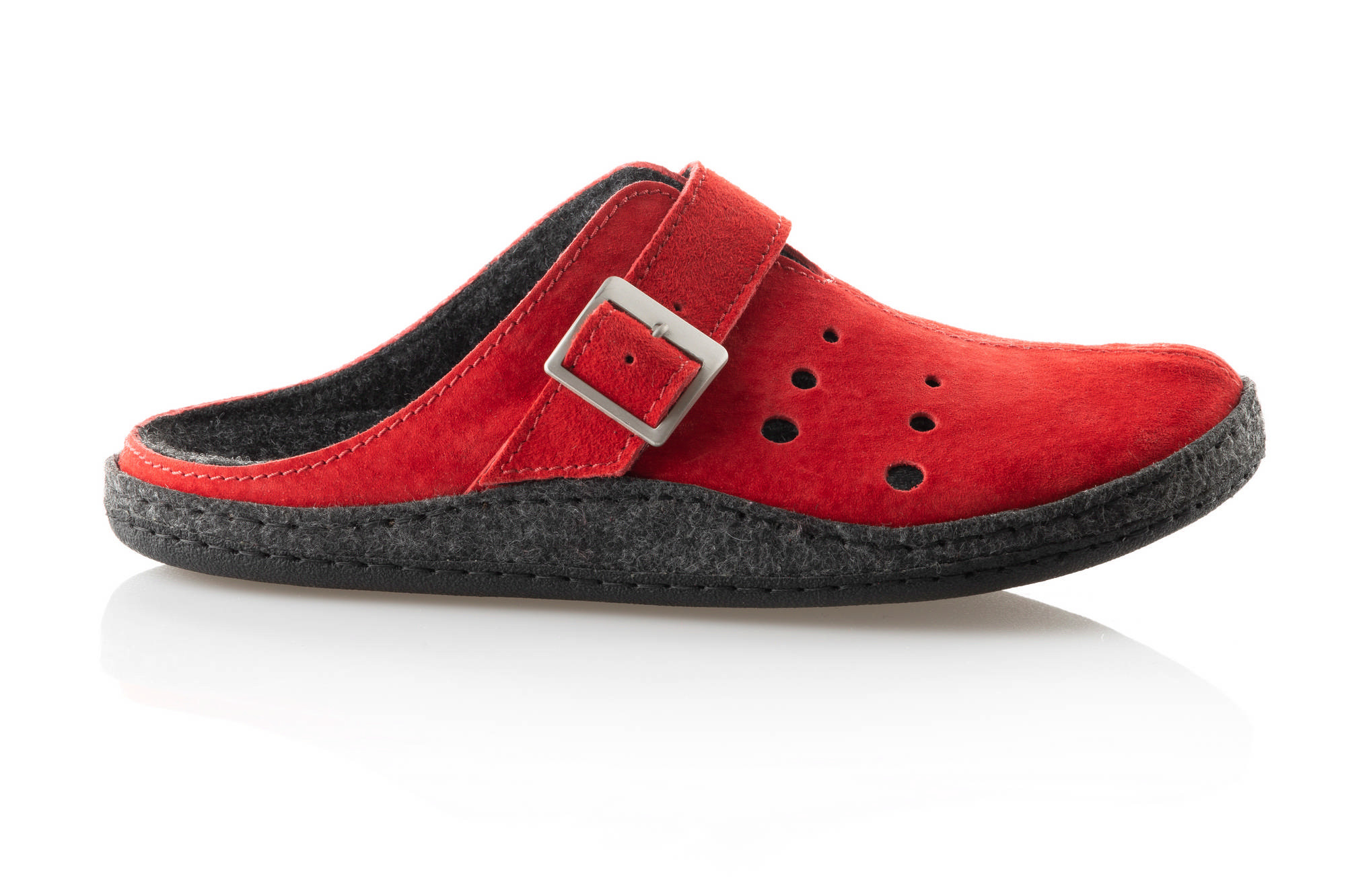 Czerwony, miękki pantofel z czarną podeszwą i metalową klamrą, z perforacjami na wierzchu.