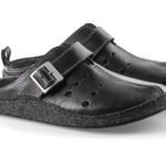 Czarne kapcie z regulowanym paskiem i miękką, filcową podeszwą, przeznaczone do użytku domowego.