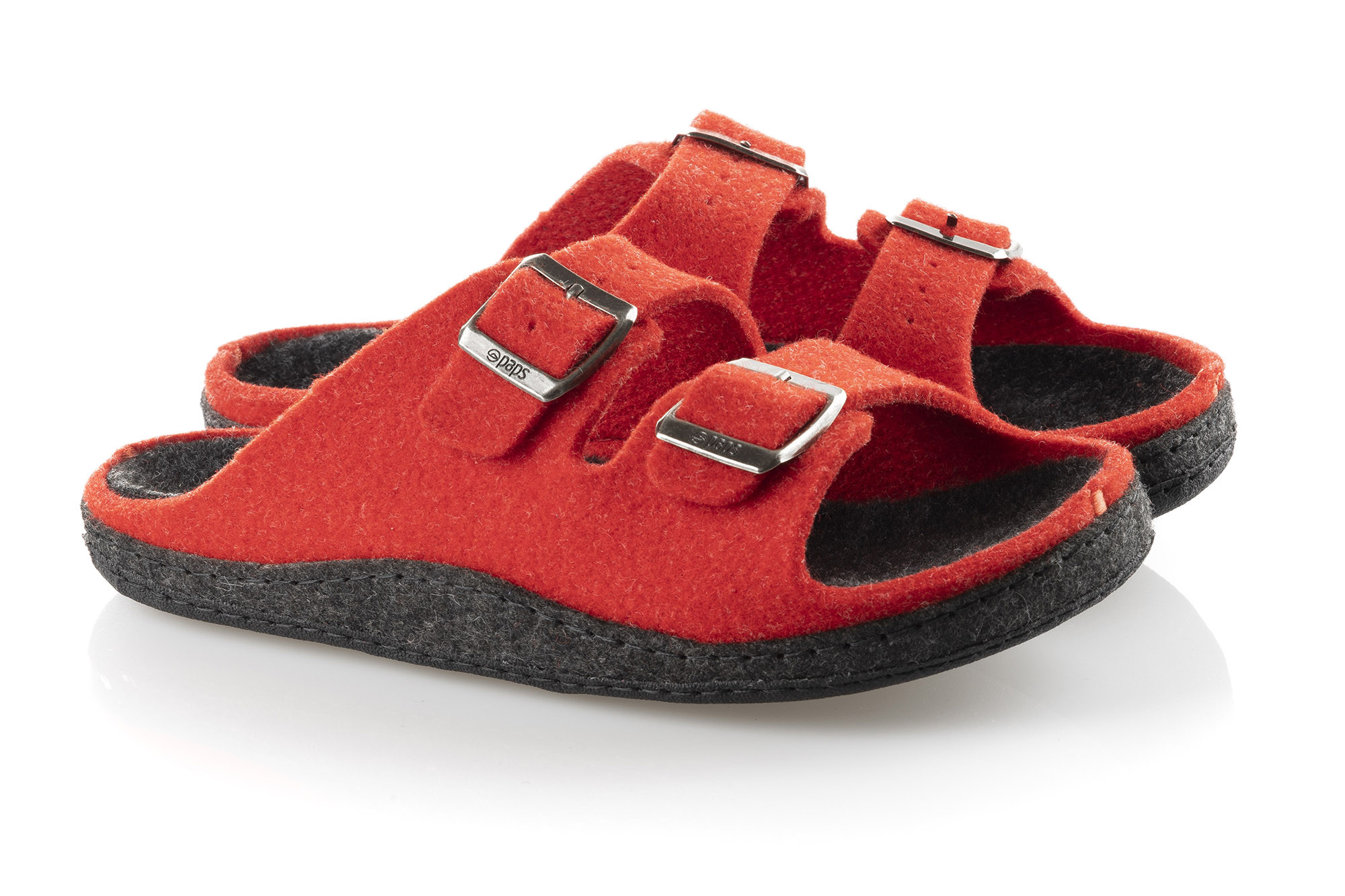 Czerwone kapcie z czarną podeszwą i trzema metalowymi klamrami na górze.
