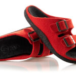 Czerwone kapcie z czarną podeszwą i dwoma regulowanymi paskami na klamry.