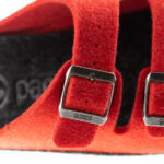 Czerwone paski z metalowymi klamrami na czarnym, miękkim materiale, z widocznym logo pade.