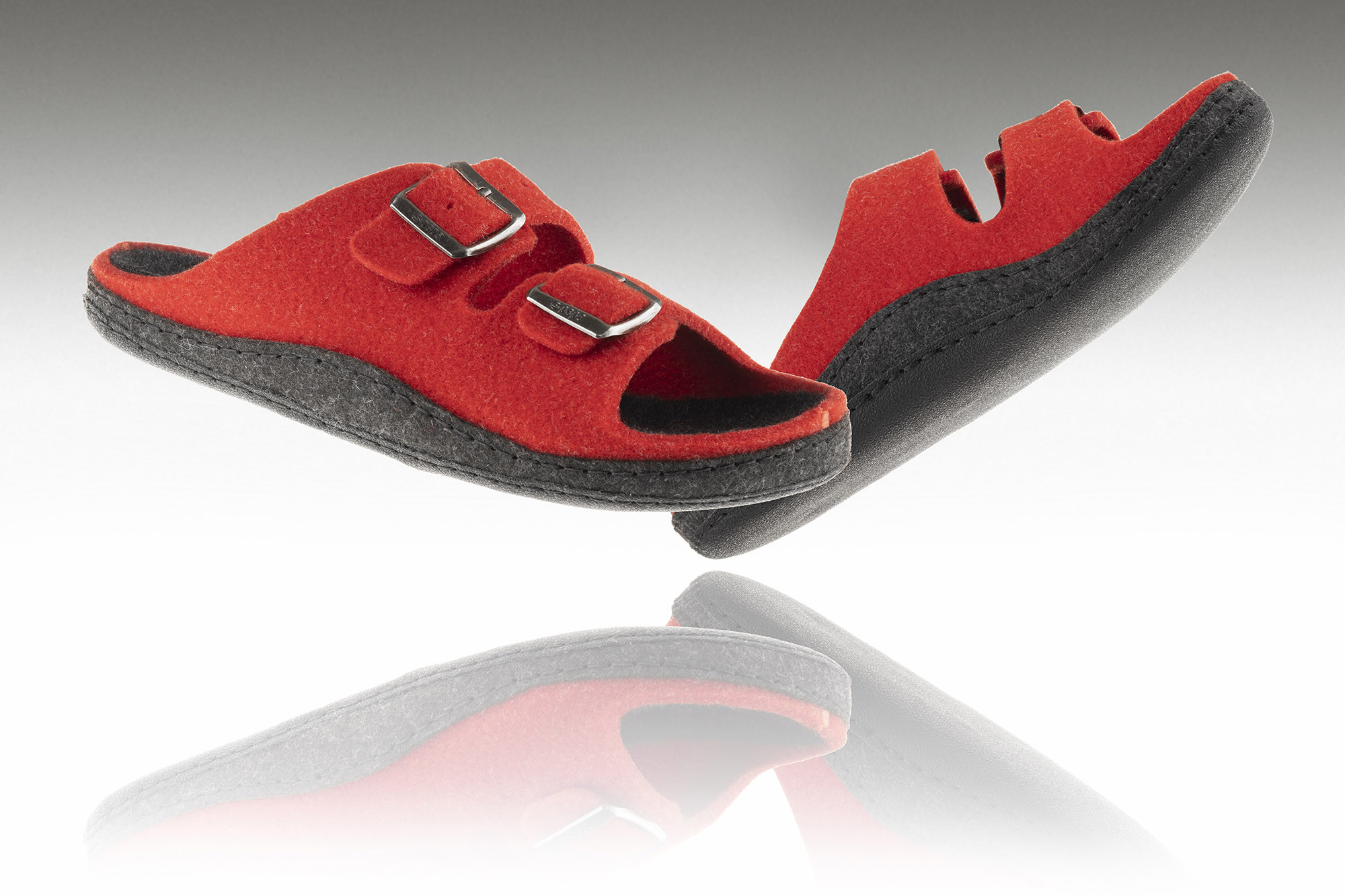 Czerwone kapcie profilaktyczne z czarną podeszwą i dwoma regulowanymi paskami na rzepy.