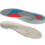 Wkładki ortopedyczne do butów, z czerwonymi i niebieskimi elementami, mają wyprofilowane kształty i różne tekstury.