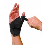 Osoba zakłada na rękę ortozę z regulowanym paskiem, wspierającą nadgarstek i kciuk.