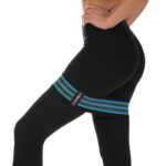 Osoba w czarnych legginsach i pasie treningowym z logo HMS, trzyma się za brzuch, od pasa w dół.