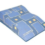 Poduszka ortopedyczna z niebieskim pokrowcem i żółtymi kwadratami, przeznaczona do podparcia głowy lub pleców.