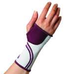 Ręka w sportowym ortezie na nadgarstek w kolorze fioletowo-białym z czarnymi i fioletowymi paskami.