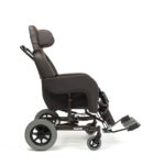 Lekki, czarny wózek inwalidzki z regulowanym zagłówkiem i podnóżkami, na czterech kołach, z metalową ramą.