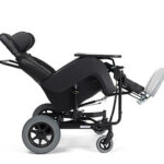 Wózek inwalidzki z regulowanym siedzeniem i podnóżkiem, czarną ramą i dużymi tylnymi kołami.