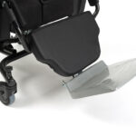 Podnóżek i kółka wózka inwalidzkiego z czarnym siedziskiem i metalową ramą.