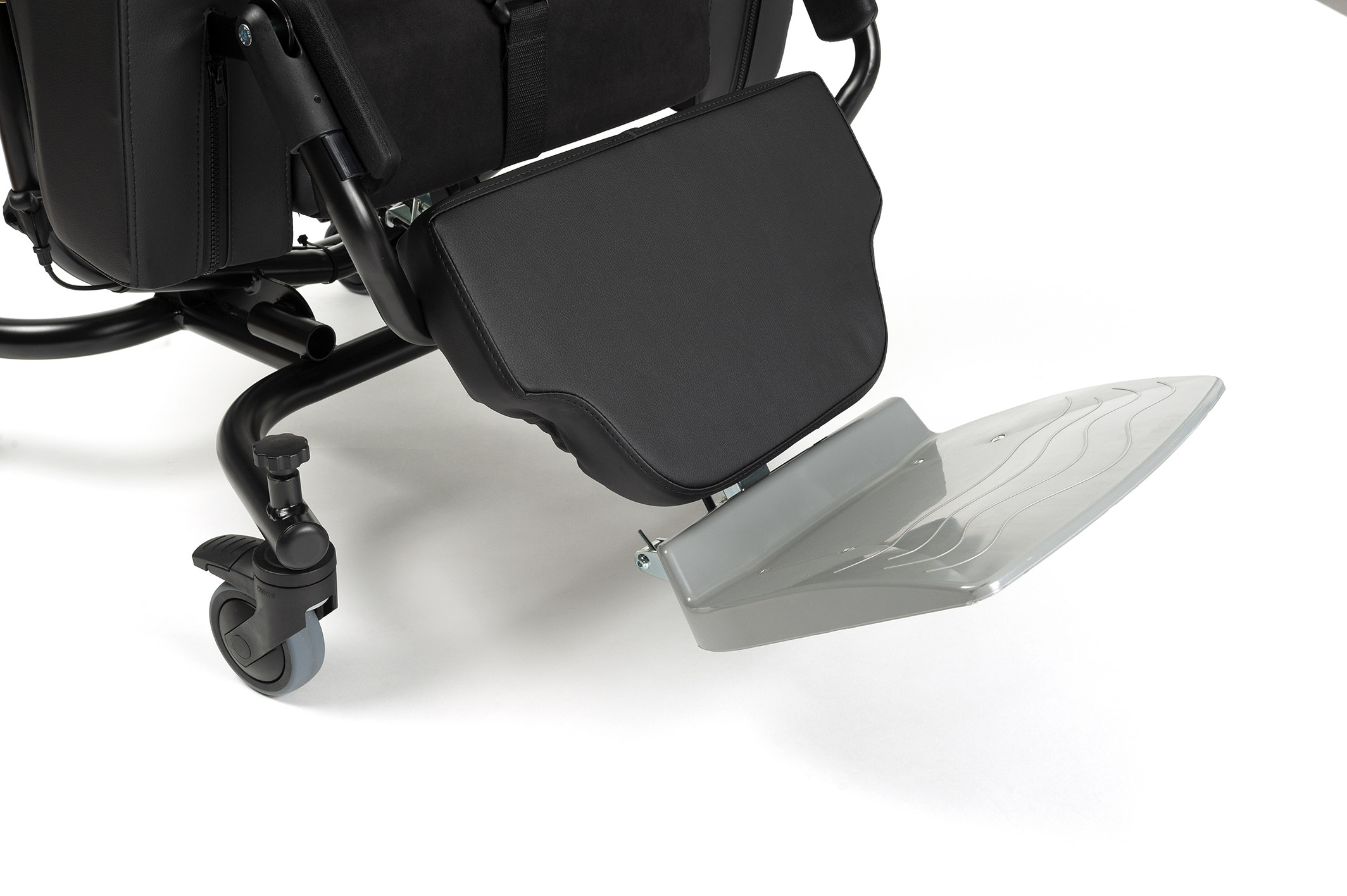 Podnóżek i kółka wózka inwalidzkiego z czarnym siedziskiem i metalową ramą.