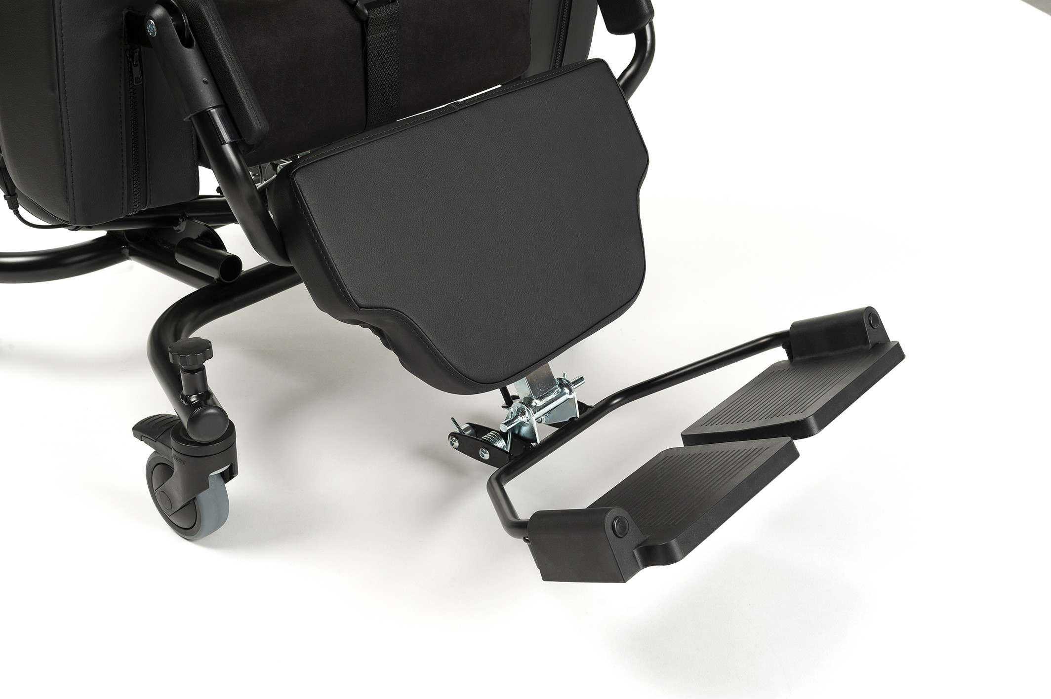 Kółka, czarna poduszka i składane stopki wózka inwalidzkiego na białym tle.