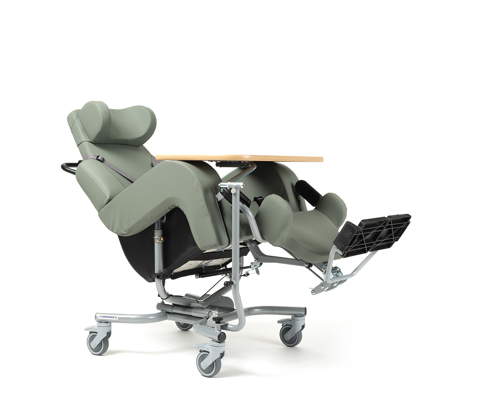 Szpitalny fotel do opieki z podnóżkiem, regulowanym zagłówkiem i drewnianym blatem, na kółkach, w kolorze oliwkowym.