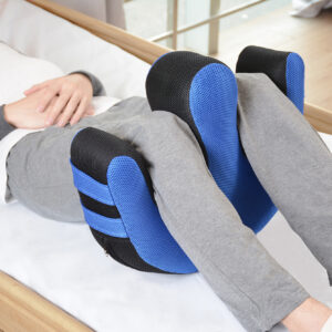 Osoba leżąca na łóżku, korzystająca z poduszki ortopedycznej na kolanach, w domu, w naturalnym świetle.