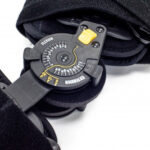 Obiektyw do aparatu fotograficznego z regulacją ostrości, umieszczony w czarnym etui na miękkim materiale.