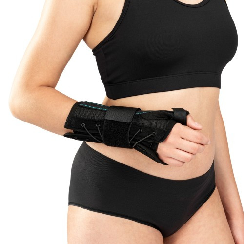 Osoba w sportowym stroju z opaską na nadgarstek, prawdopodobnie do ćwiczeń lub rehabilitacji.