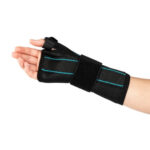 Orteza na nadgarstek z czarnym materiałem i niebieskimi liniami, zabezpieczająca i stabilizująca staw.