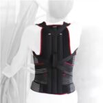 Czarna kamizelka z czerwonymi i białymi paskami, wyłożona na białym tle, z zamkami i regulowanymi paskami.