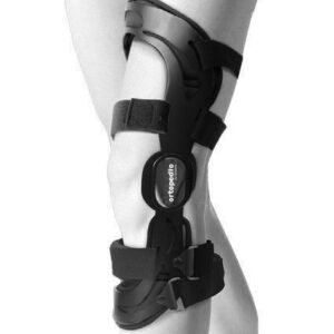 Kobieta nosi stabilizator kolana z paskami i zapięciami, oznaczony logo ortopedico.