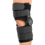 Orteza kolana z regulowanym zaciskiem i paskami mocującymi, zapewniająca stabilizację i wsparcie stawu kolanowego.