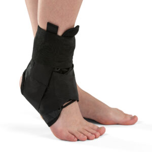 Stopa i kostka uwięziona w czarnym stabilizatorze na kostkę, z otwartym zapięciem i elastycznym paskiem.