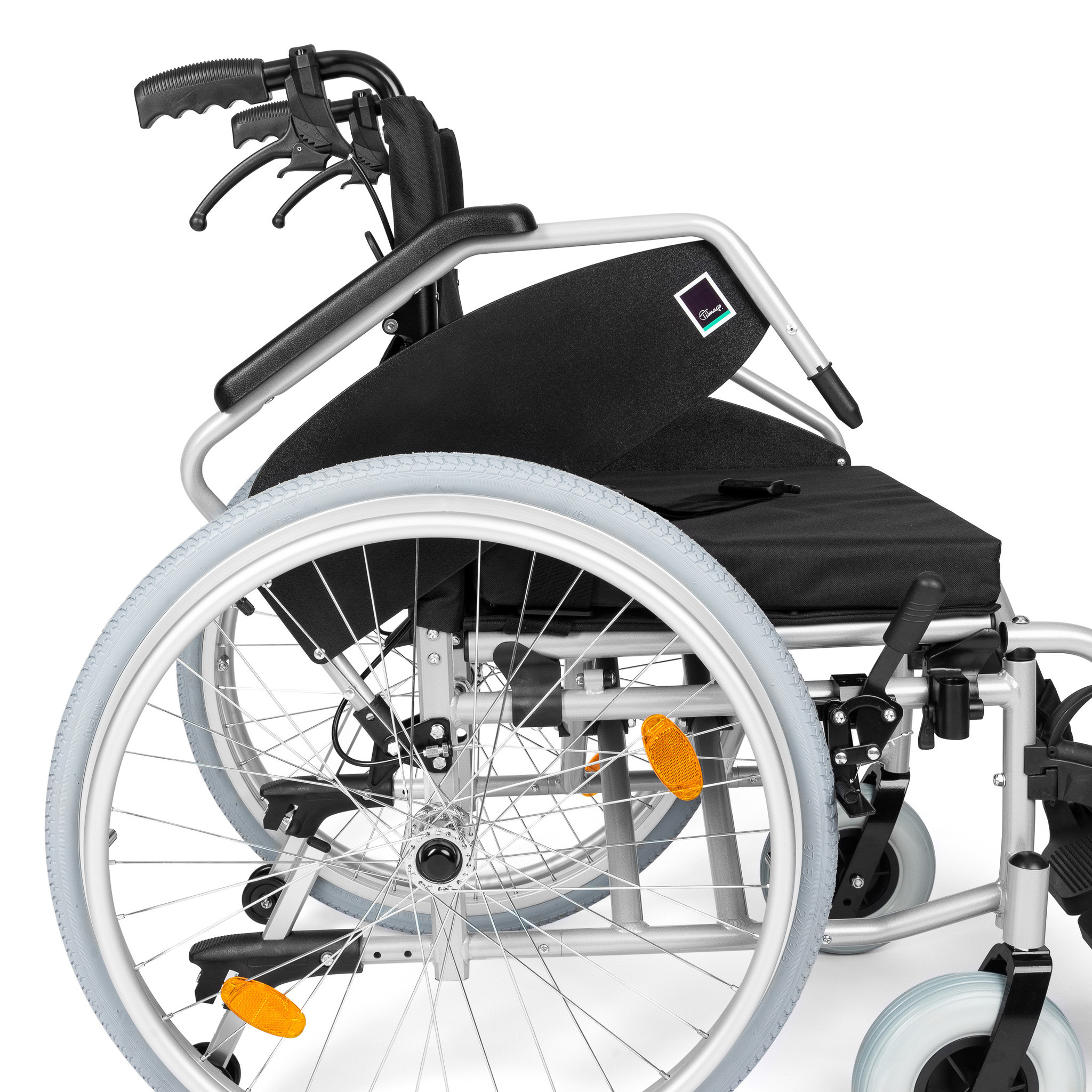 Lekki wózek inwalidzki z czarnym siedziskiem, metalową ramą i dużymi białymi kołami.