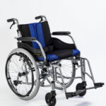 Wózek inwalidzki z czarno-niebieskim siedziskiem i oparciem, na białym tle, z dużymi kołami i małymi przednimi kółkami