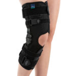 Orteza na kolano z czarnym materiałem, regulowanymi paskami i elementami do monitorowania stanu zdrowia.