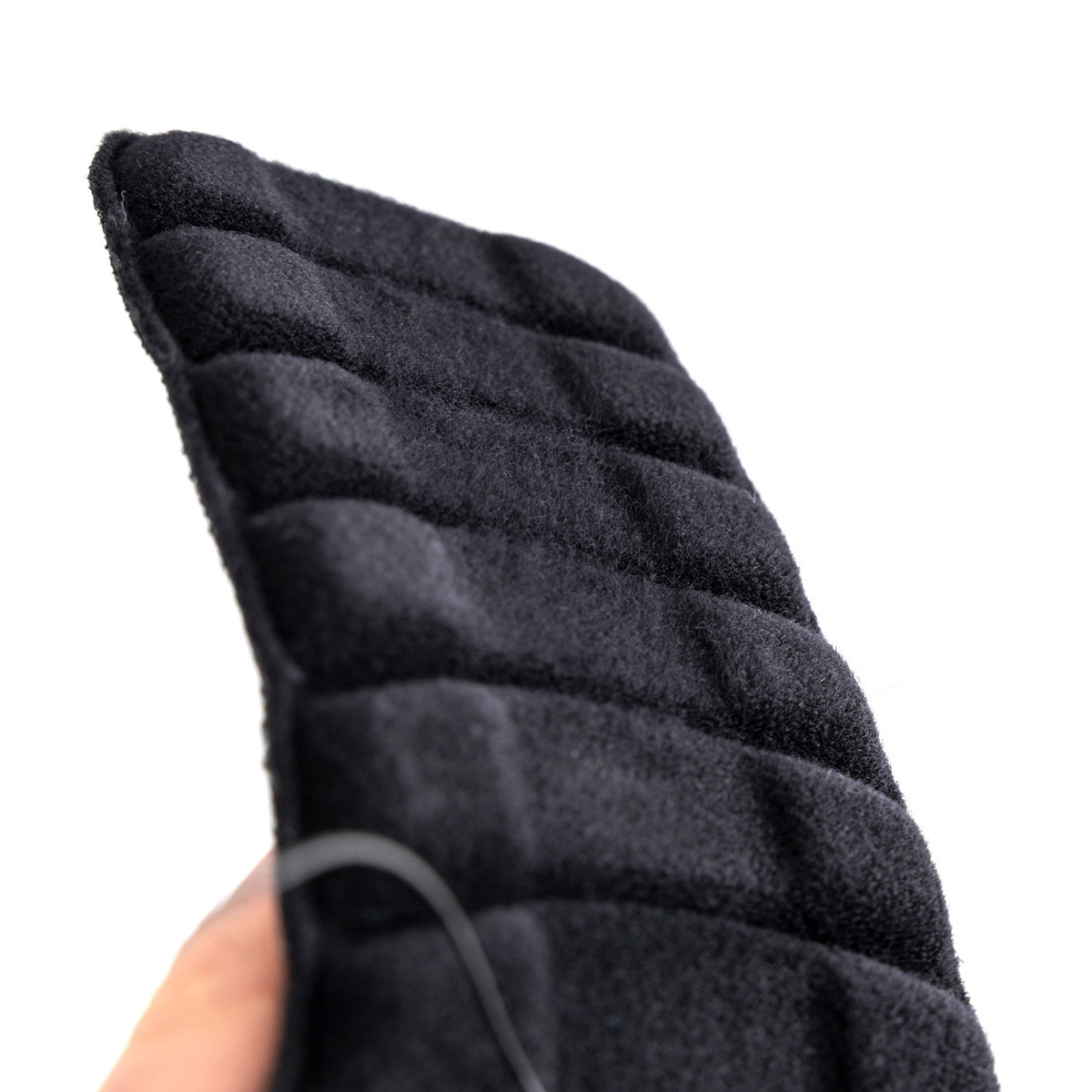 Czarna, puchowa rękawica z wyraźnym pikowaniem, trzymana przez osobę na tle białego.