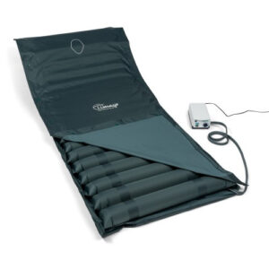 Poduszka do masażu z elektrycznym napędem, rozłożona na czarnym pokrowcu, z podłączonym urządzeniem sterującym.