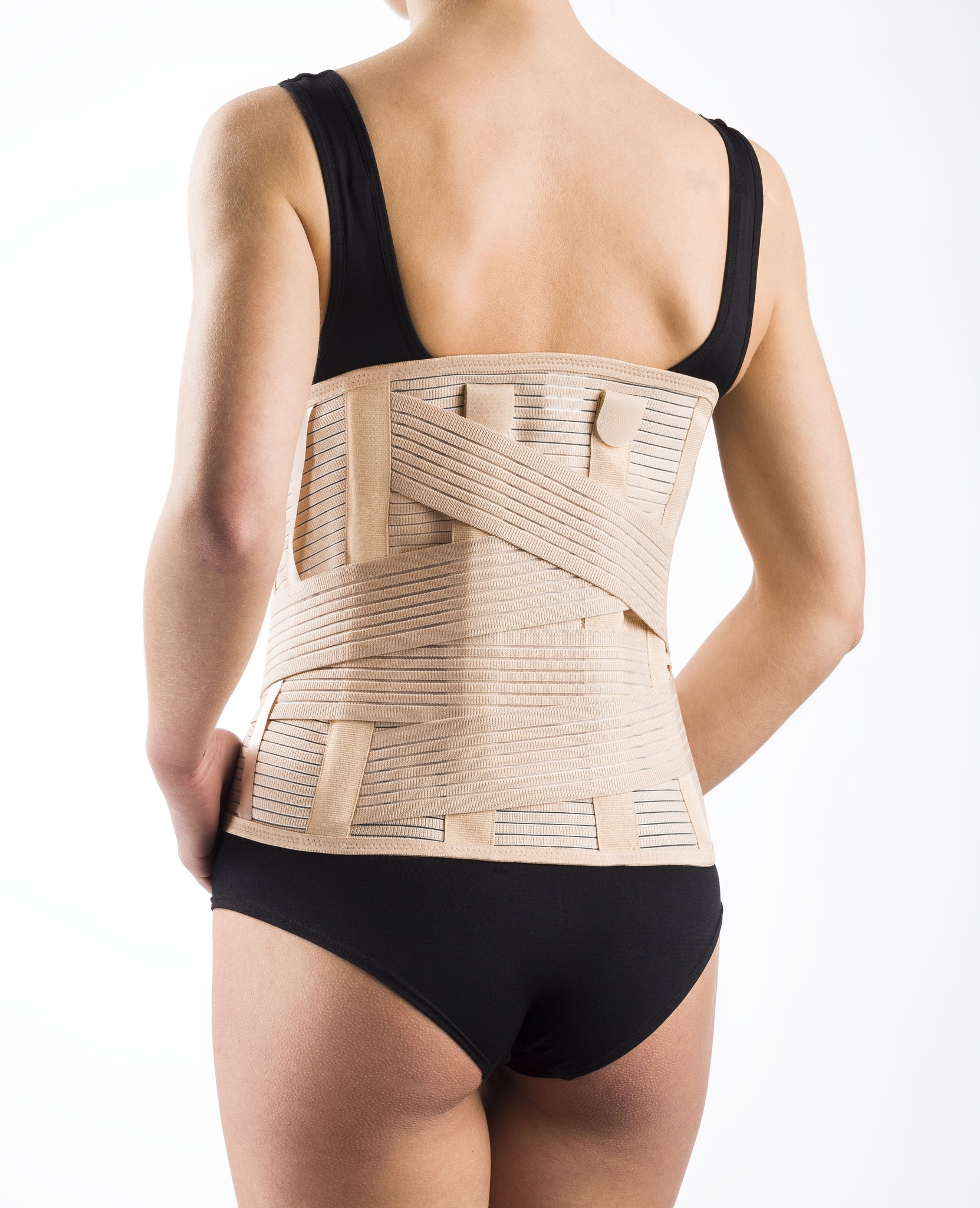 Osoba z czarnym topem i czarnymi majtkami nosi na plecach ortezę lędźwiowo-krzyżową.