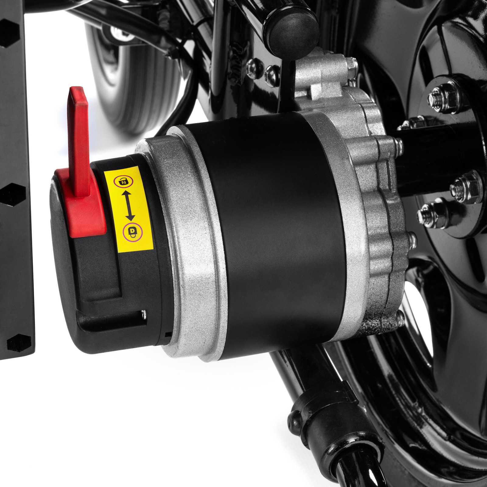 Silnik elektryczny z czerwonym przełącznikiem i żółtą naklejką z symbolami i strzałką, zamontowany na ramie pojazdu.