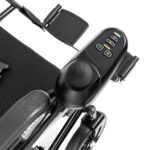 Sterownik elektrycznego wózka inwalidzkiego z przyciskami do sterowania i wskaźnikami na czarnym panelu.