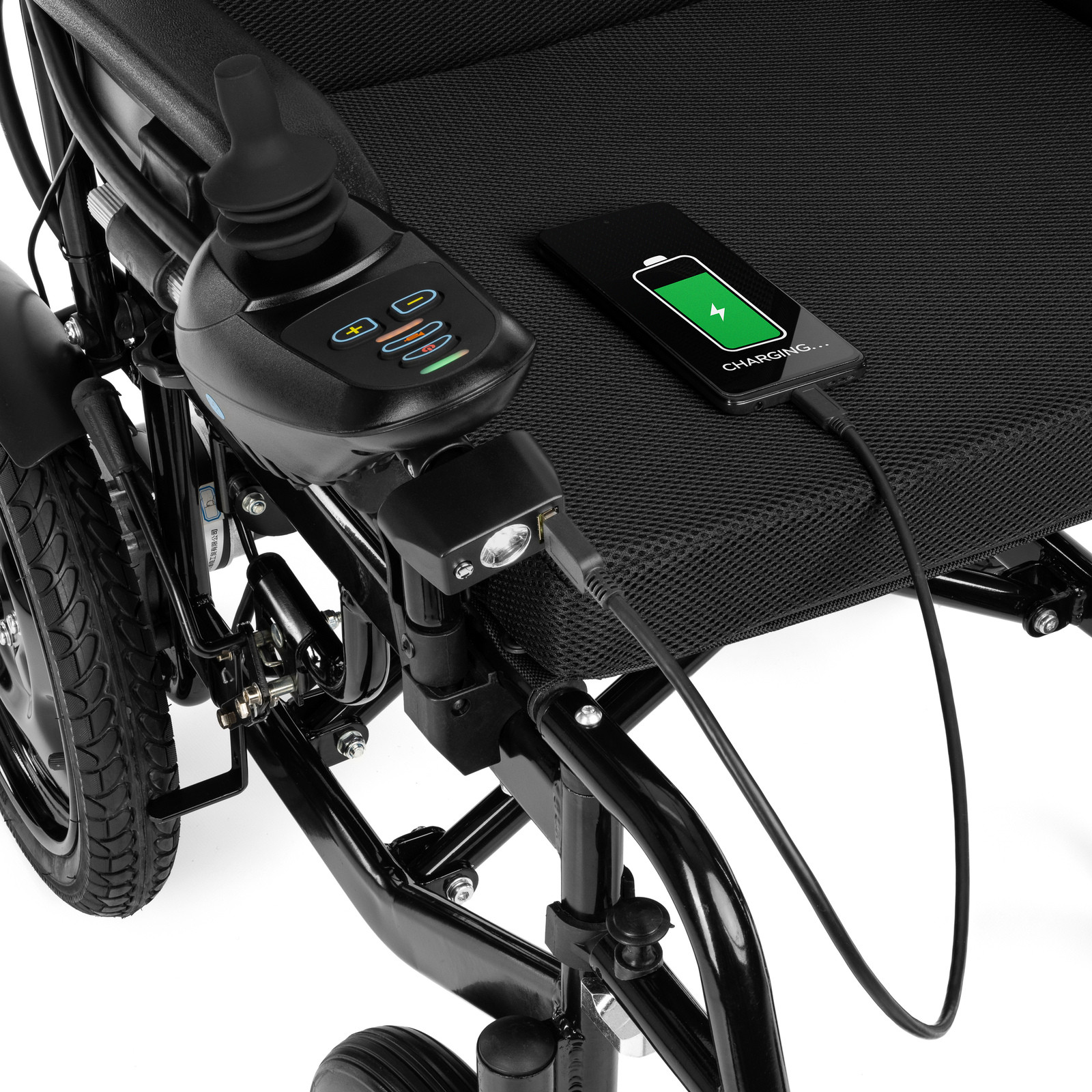 Elektryczny wózek inwalidzki z ładowarką i telefonem na podłodze, pokazującym ładowanie baterii.