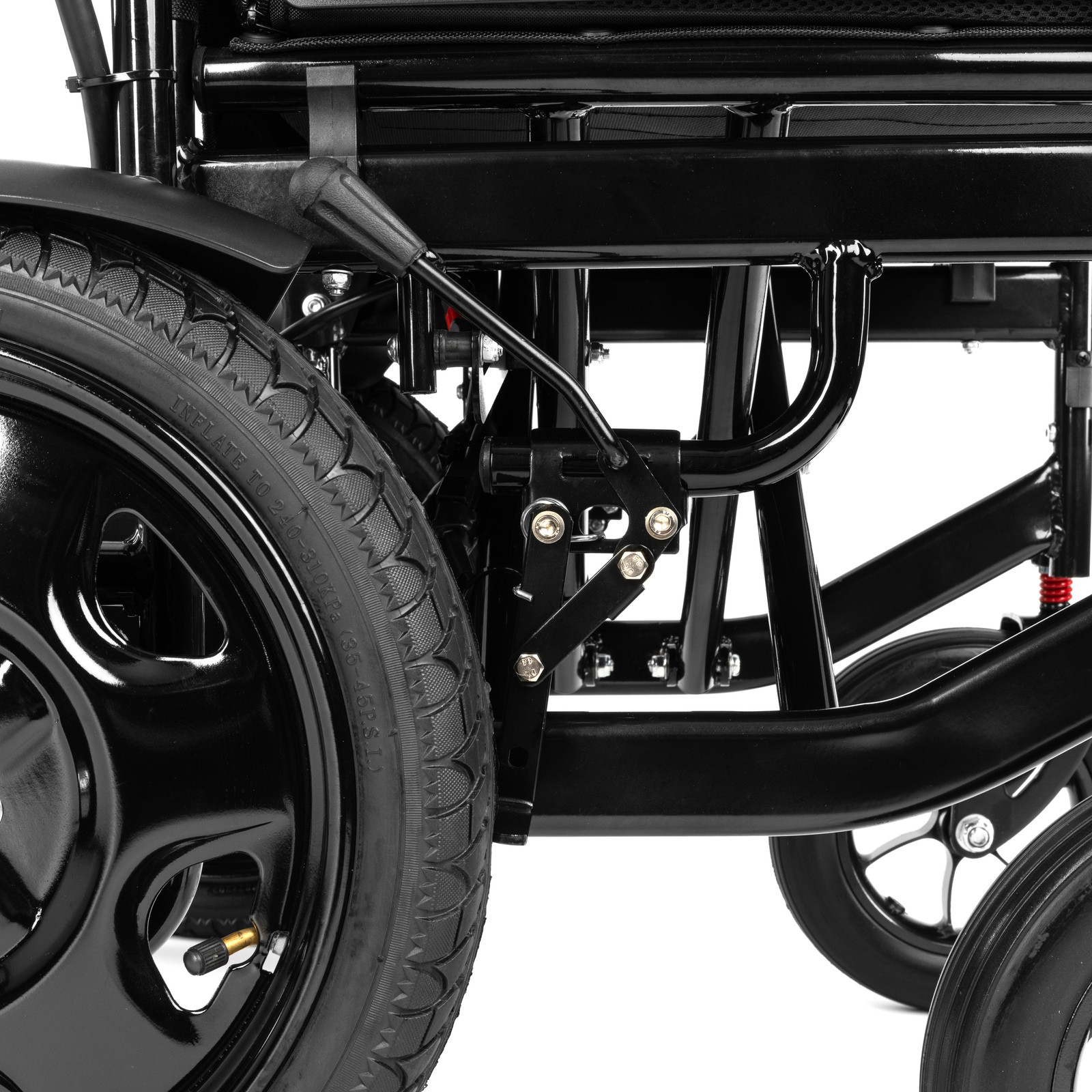 Blisko widoczny czarny wózek inwalidzki z dużym kołem i metalowymi elementami konstrukcyjnymi.