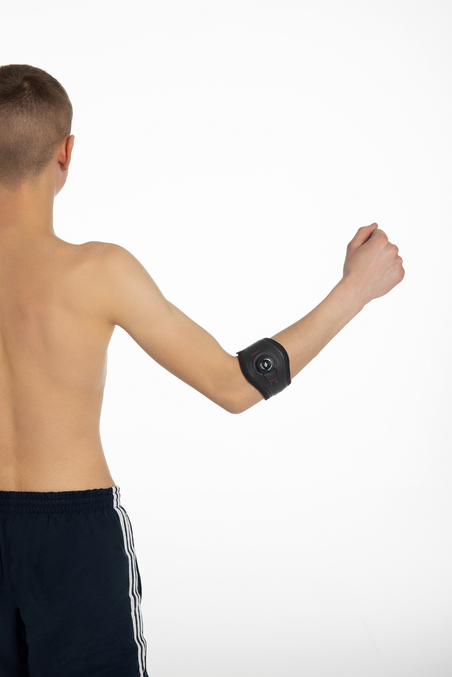 Mężczyzna bez koszulki z opaską na ramieniu zawierającą czujnik, unosi zaciśniętą pięść w geście triumfu lub moty