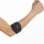 Ręka z uniesionym pięścią, na przedramieniu czujnik do pomiaru ciśnienia krwi.