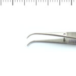 Para narzędzi chirurgicznych z zakrzywionymi końcówkami, jedno w powiększeniu, drugie na płaskiej powierzchni.