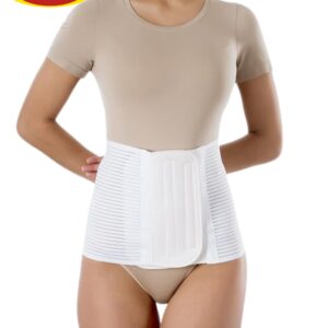 Osoba nosząca białą opaskę lędźwiową, ubrana w beżowy t-shirt i majtki, z rękami za plecami, na tle białego tła.